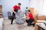 Movers dismantling and packing furniture